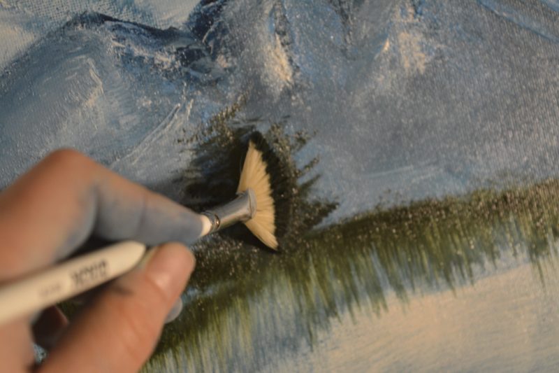 Use the fan brush to paint evergreens